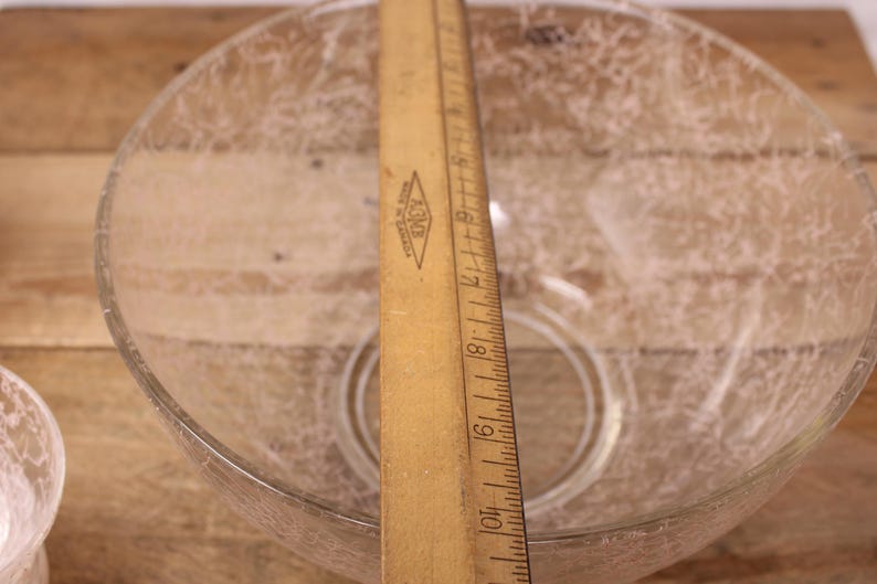 May include: A clear glass bowl with a textured surface. The bowl is approximately 25 cm in diameter.