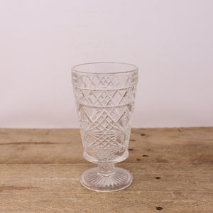 May include: A clear glass goblet with a cut glass design and a pedestal base.