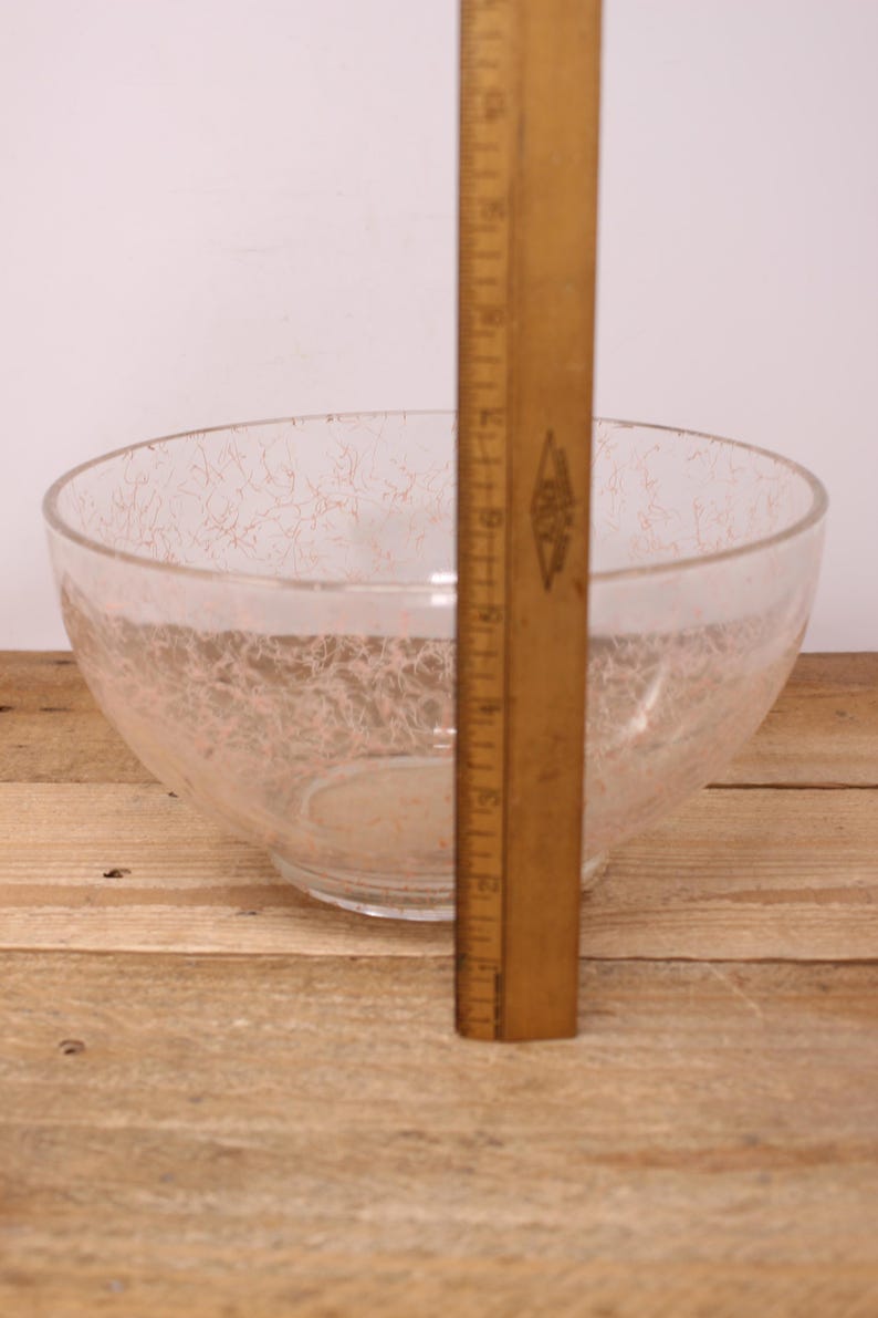 May include: A clear glass bowl with a pink crackle design. The bowl is approximately 18 cm in diameter.