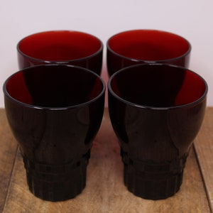 Peut inclure: Ensemble de quatre verres à boire en verre rouge foncé avec une base texturée.