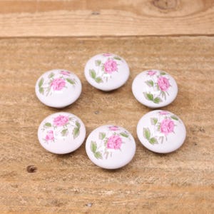 Peut inclure: Une tasse en céramique blanche avec une anse noire et le texte "But First, Coffee" en noir, dans une police manuscrite. La tasse est posée sur une surface blanche.