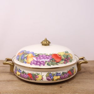 May include: White enamel pot with a brass lid and handles. The pot is decorated with a colourful fruit design.