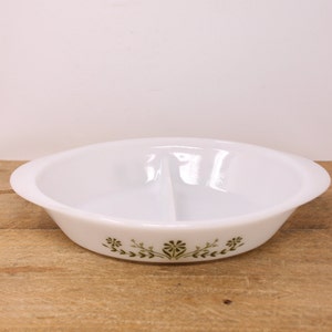May include: White oval divided serving dish with green floral pattern. The dish has a handle on each side and a central divider. The floral design is repeated along the bottom edge of the dish.
