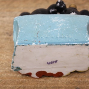 May include: A blue ceramic figurine of Mickey Mouse sitting on a chair. The figurine is marked "&copy; WALT DISNEY" and "JAPAN" on the bottom.
