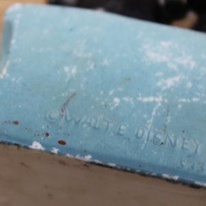 May include: Close-up of a blue ceramic figurine with the text "&copy; WALT DISNEY" and "5185" on the bottom.