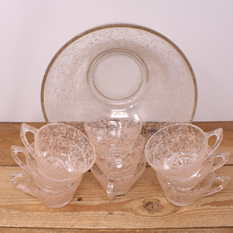 May include: A set of six clear glass punch cups with a pink crackle design and a matching clear glass punch bowl with a pink crackle design.