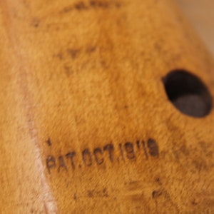 May include: Close-up of a wooden object with a round hole and the text "PAT. OCT 19 1919" engraved on the surface.