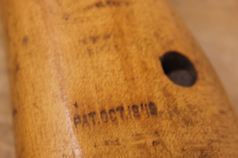 May include: Close-up of a wooden object with a round hole and the text "PAT. OCT 19 1919" engraved on the surface.