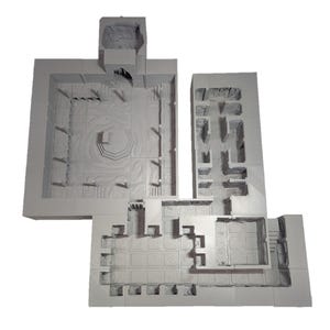 May include: A gray 3D printed model of a dungeon or castle interior. The model features multiple rooms and hallways, with walls, floors, and ceilings. The model is designed for tabletop gaming or miniature display.