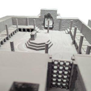 May include: A 3D printed model of a stone building with a central altar and columns. The model is painted in a light gray color.