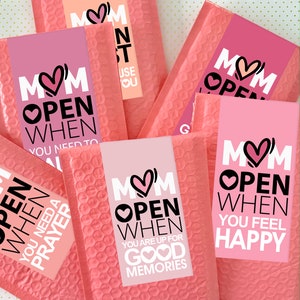 May include: Pink envelopes with white labels that say "Mom Open When" with different reasons to open the envelope. The reasons include "You Need to Pray", "You Are Up For Good Memories", and "You Feel Happy".