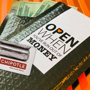 Może przedstawiać: Czarno-biała karta podarunkowa z tekstem "OPEN WHEN YOU'VE RUN OUT OF MONEY" i czerwonym sercem. Karta podarunkowa jest do Chipotle Mexican Grill.
