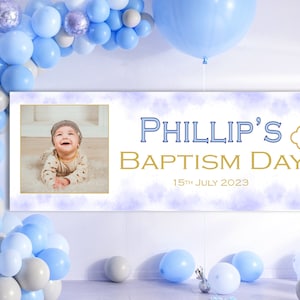 May include: A white banner with a purple watercolour background and a gold cross. The banner says "Phillip's Baptism Day" with the date "15th July 2023". A photo of a baby boy is in the top left corner.