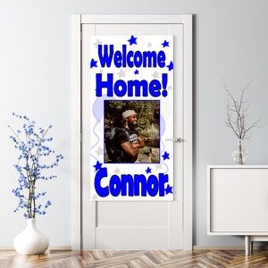 Puede incluir: Pancarta de bienvenida a casa con un esquema de color azul y blanco. La pancarta presenta una foto de una persona, las palabras "Welcome Home!" y el nombre "Connor" en texto azul.