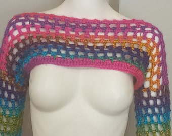 Op de afbeelding: Een regenboog gehaakt topje met lange mouwen. Het topje is gemaakt met een eenvoudige steek en heeft een losse pasvorm.