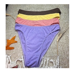 May include: Four pairs of underwear in different colors: purple, pink, yellow, and brown. The underwear is made of a soft, stretchy fabric.