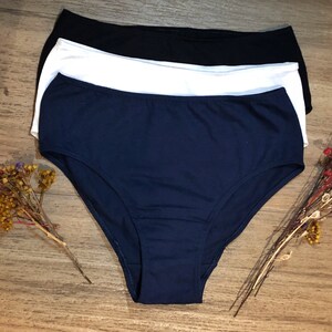 May include: Three pairs of underwear in navy blue, white, and black. The underwear is made of a soft, stretchy fabric.
