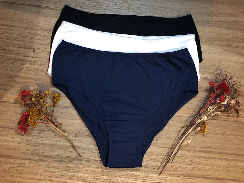 May include: Three pairs of underwear in navy blue, white, and black. The underwear is made of a soft, stretchy fabric.