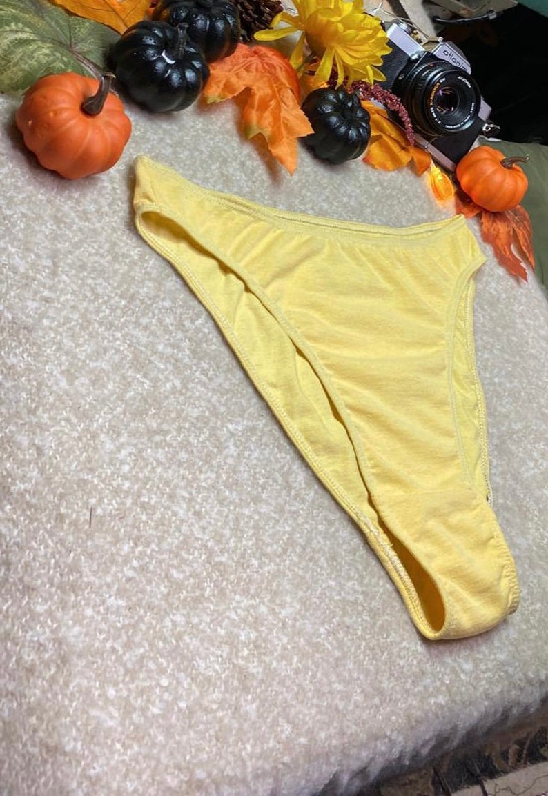 May include: A pair of yellow cotton underwear with a high leg cut.