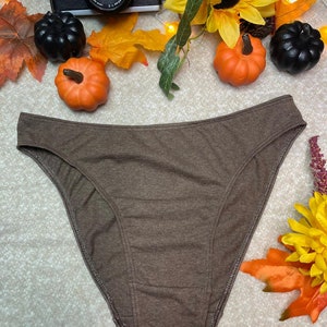 May include: A brown high-cut underwear with a smooth, textured fabric.