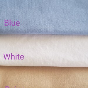 May include: Three fabric swatches, one blue, one white, and one beige. The swatches are stacked on top of each other.