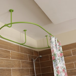 May include: A green metal shower curtain rod is installed in a corner of a bathroom. The rod is curved and has a white shower curtain with a floral pattern hanging from it.