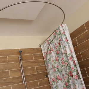 May include: A curved shower curtain rod made of stainless steel with a floral shower curtain. The shower curtain is white with pink, red, and green flowers.