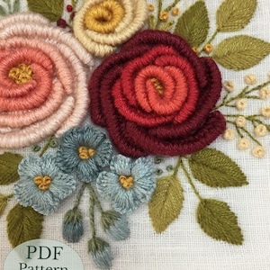 May include: Close-up of an embroidered floral design featuring a variety of flowers in shades of pink, yellow, and red, with green leaves. The text "PDF Pattern 6" Hoop" is visible.