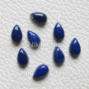 Puede incluir: Ocho cabujones de lapisl&aacute;zuli en forma de l&aacute;grima, cada uno con un color azul intenso y motas de pirita dorada.