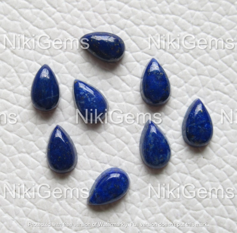 Puede incluir: Ocho cabujones de lapisl&aacute;zuli en forma de l&aacute;grima, cada uno con un color azul intenso y motas de pirita dorada.