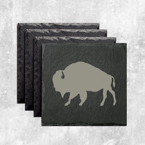 May include: Set of four black slate coasters with a gray buffalo silhouette design.