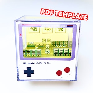 Op de afbeelding: Een transparante plastic doos met een miniatuur-diorama van een videogame. Het diorama toont een kamer met meubels en een personage uit het spel. De doos heeft een label met de tekst "Nintendo GAME BOY TM".