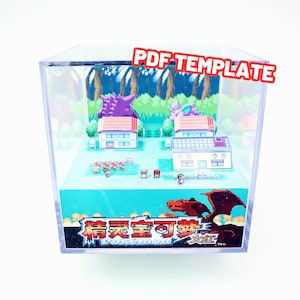 May include: A clear plastic cube display case with a miniature 3D diorama of a Pokemon video game scene. The diorama features a green grassy area with two houses, a few trees, and several small Pokemon characters. The bottom of the case has a red and orange Pokemon character with the text "Pokemon" and "Fire Red" in Japanese and English.