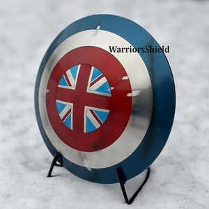 May include: A round shield with a blue outer rim, a silver central band, and a red and blue center design. The center features a Union Jack design. The text "WarriorsShield" is visible on the shield.