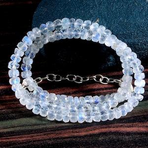 Op de afbeelding: Een witte maansteen ketting met een zilveren ketting. De ketting is gemaakt van gefacetteerde kralen en heeft een iriserende glans.