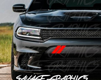 May include: A black Dodge Charger with a red stripe decal on the front bumper. The decal reads "SAVAGE GRAPHICS".