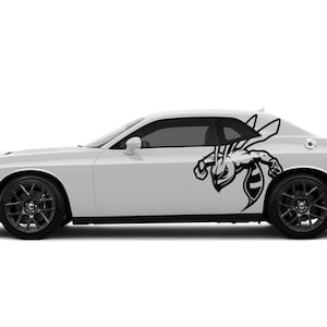 May include: A white Dodge Challenger with a black wasp graphic decal on the side of the car.
