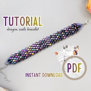May include: A dragon scale bracelet featuring iridescent purple, blue, and green beads arranged in a textured pattern. The bracelet includes a silver-toned metal clasp and an adjustable chain. A PDF tutorial document is visible in the corner.