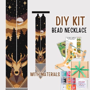 Op de afbeelding: DIY kralenkettingset met materialen. De set bevat een houten weefgetouw, kralen in verschillende kleuren en een patroon voor een hert in een boslandschap. De set is verpakt in een bruine doos met een groen lint.