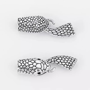 Peut inclure: Deux fermoirs &agrave; glissi&egrave;re en forme de serpent argent&eacute;s avec un motif textur&eacute; et &eacute;cailleux. Les fermoirs sont con&ccedil;us pour &ecirc;tre utilis&eacute;s comme fermeture pour des colliers, des bracelets ou d'autres bijoux.