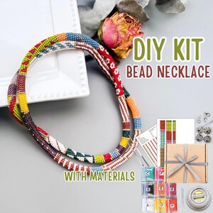 Puede incluir: Un kit de collar de cuentas DIY con materiales. La imagen muestra dos collares de cuentas coloridos con cuentas rojas, amarillas, azules y verdes. El kit incluye cuentas, instrucciones y otros suministros. El texto en la imagen dice "DIY KIT BEAD NECKLACE WITH MATERIALS."