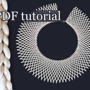 Könnte beinhalten: Weiße Perlenkette mit geometrischem Muster. Die Kette hat die Form eines Kragens und wird mit einem PDF-Tutorial geliefert.