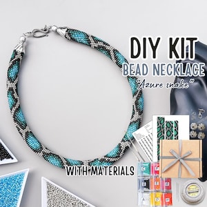 May include: DIY kit for a beaded necklace with a turquoise and silver snake pattern. The kit includes all the materials needed to create the necklace, including beads, thread, and instructions. The kit is packaged in a box with a ribbon.