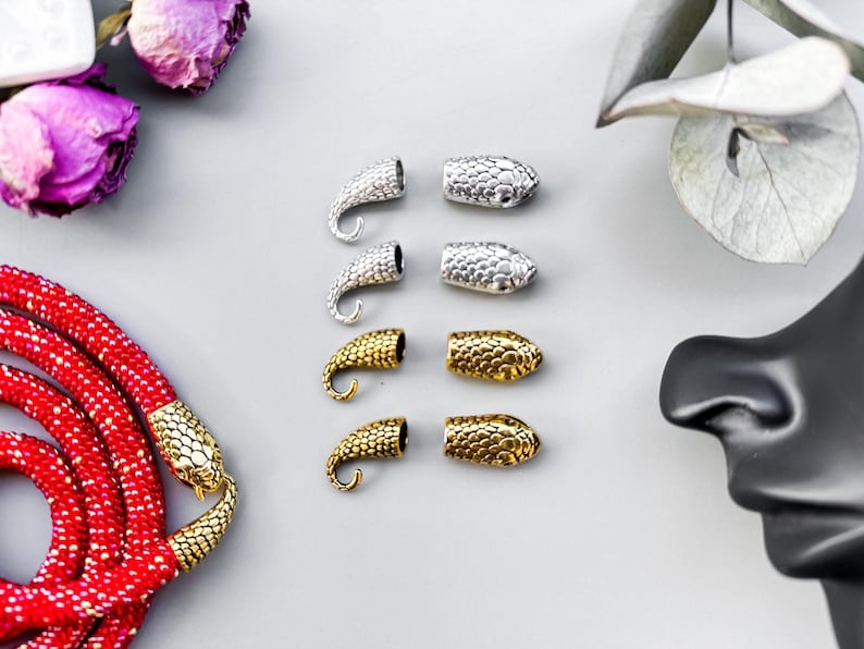 Peut inclure: Six embouts en m&eacute;tal en forme de serpent pour la fabrication de bijoux. Trois sont argent&eacute;s et trois sont dor&eacute;s.
