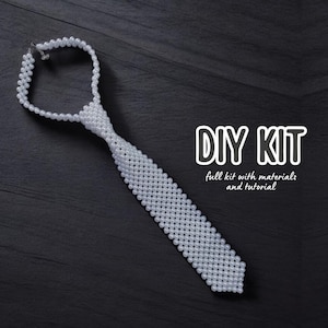 Könnte beinhalten: DIY-Set zum Basteln einer weißen Perlen-Krawatte. Das Set enthält alle Materialien und eine Anleitung.