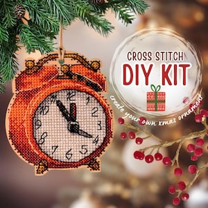 May include: A red and white cross stitch kit to create a Christmas ornament shaped like an alarm clock. The kit includes all the materials needed to create the ornament, including the fabric, thread, and needle. The ornament is a fun and festive way to add a touch of personality to your Christmas tree.