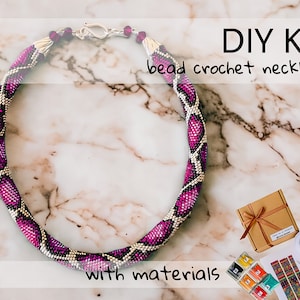 Può includere: Kit fai-da-te per realizzare una collana a uncinetto con perline. Il kit include tutti i materiali necessari, tra cui perline, filo e istruzioni. La collana è rosa e bianca con un motivo a pelle di serpente.