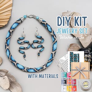 May include: A DIY jewelry set featuring a beaded necklace and earrings in a snake design. The necklace and earrings are blue, black, and silver. The kit includes beads, instructions, and other materials. Text on the image says "DIY KIT JEWELRY SET Winter snake WITH MATERIALS".