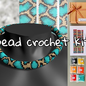 May include: A bead crochet kit with a turquoise, black, and beige beaded necklace. The kit includes beads, needles, and a pattern. The text "Bead crochet kit" is displayed. A brown gift box with a ribbon is also included.