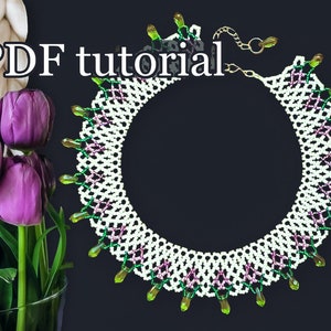 May include: White beaded necklace with green and pink accents and a PDF tutorial. The necklace has a delicate, intricate design and is perfect for adding a touch of elegance to any outfit.